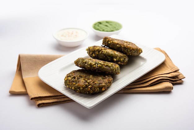 El moong dal tikki germinado o empanadas es un bocadillo saludable de la India que se sirve con chutney verde y cuajada.