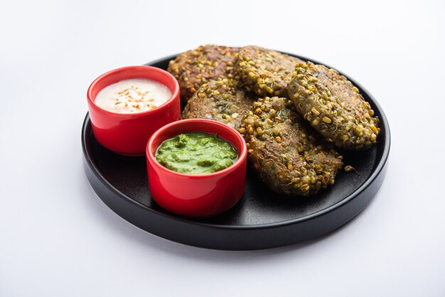 El moong dal tikki germinado o empanadas es un bocadillo saludable de la India que se sirve con chutney verde y cuajada.