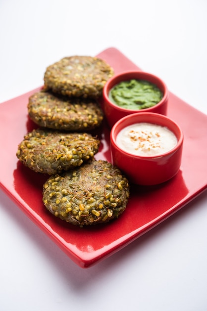 Moong dal tikki ou rissóis germinados são um lanche saudável da Índia servido com chutney verde e requeijão