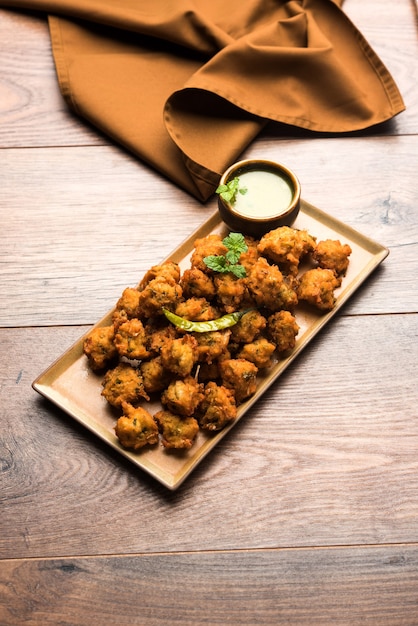 Moong Dal Vada o Pakoda también conocido como Moongode servido con salsa picante verde. enfoque selectivo