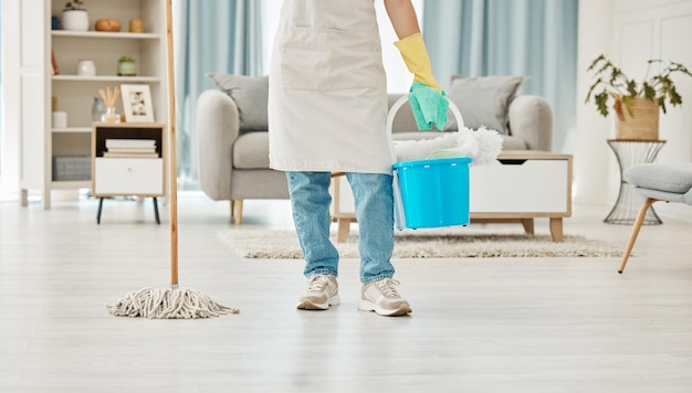 Mop de limpeza e equipamento de limpeza de primavera com mulher na sala de estar para higiene doméstica e sanitária empregada ou governanta com recipiente em casa para serviço de limpeza interior de casa ou apartamento