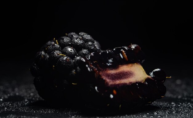 mora con gotas de agua en primer plano negro