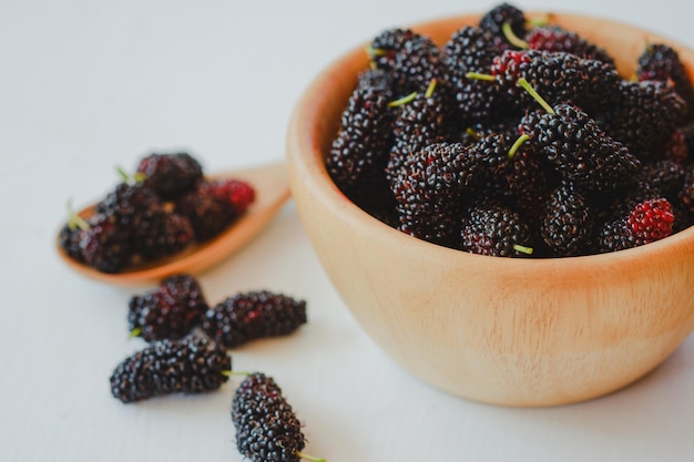 Mora negra en copa de madera Es una fruta de la familia de las bayas que tiene beneficios para la salud