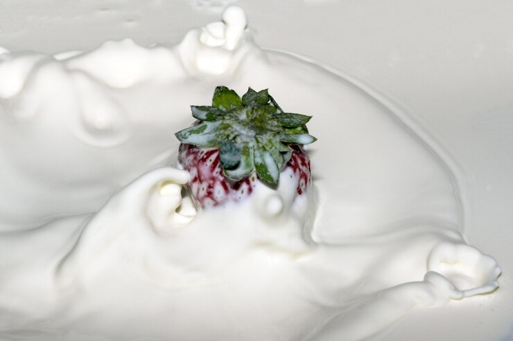 Foto morango doce maduro e fresco em creme com salpicos e bolhas de close-up