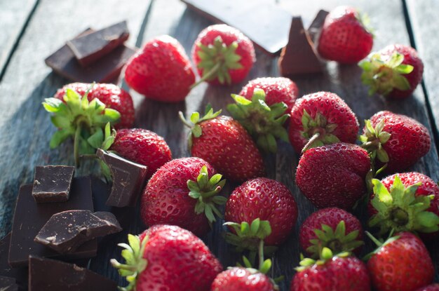 Morango e chocolate a luz brilhante da mesa velha da janela