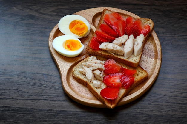 Morango e frango na torrada com ovo cozido no café da manhã.