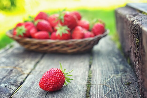 Morango em prato de vime com fundo de madeira