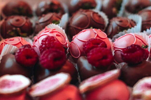 Morangos cobertos de chocolate rosa com framboesas frescas no topo Coleção de doces e doces