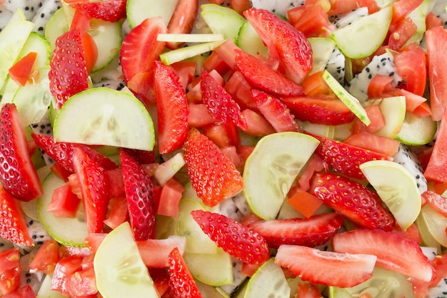 Morangos e fruta do dragão com pepinos e tomates.