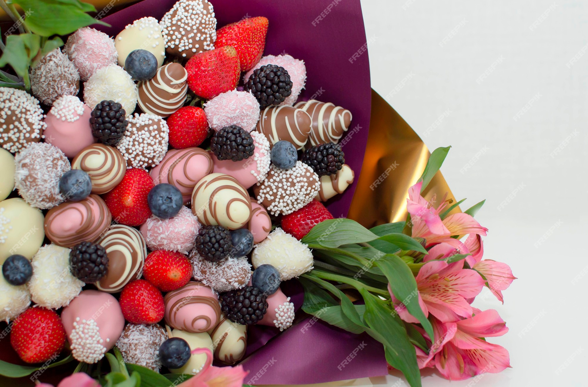 Morangos em cobertura, cobertos com chocolate em um fundo rosa, um buquê  comestível, flores. morangos mergulhados em chocolate escuro e branco em um  buquê. | Foto Premium