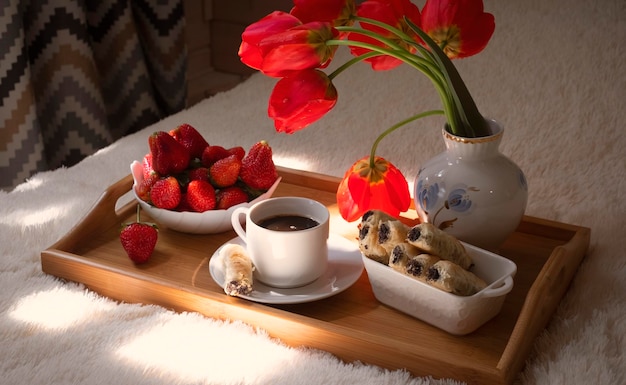 Morangos em uma bandeja com doces e flores de café café da manhã festivo da primavera