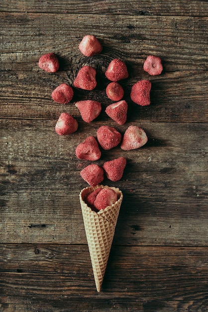 Morangos secos em cone de waffle em mesa de madeira conceito de lanche saudável fotografia plana e