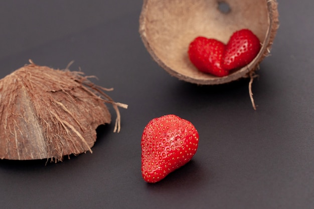 Morangos vermelhos estão na casca do coco e, isolados.