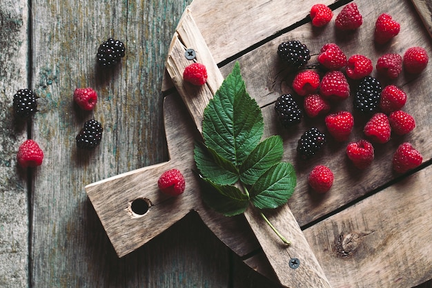 Moras y frambuesas en una tabla para cortar