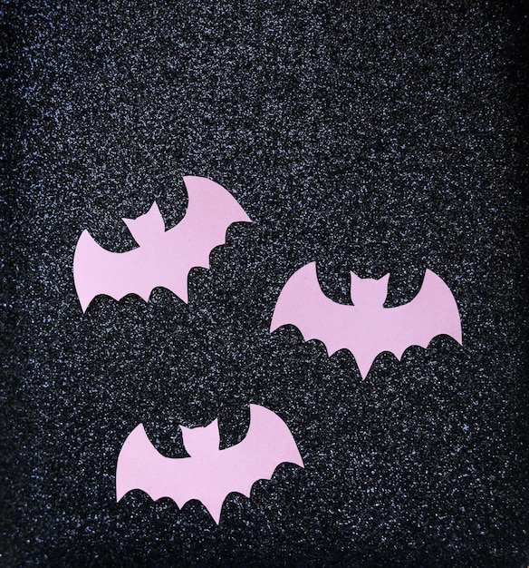 morcegos de papel rosa em um fundo de brilho preto conceito de Halloween