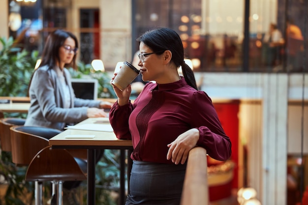 Foto morena atractiva joven disfrutando de su café de aroma