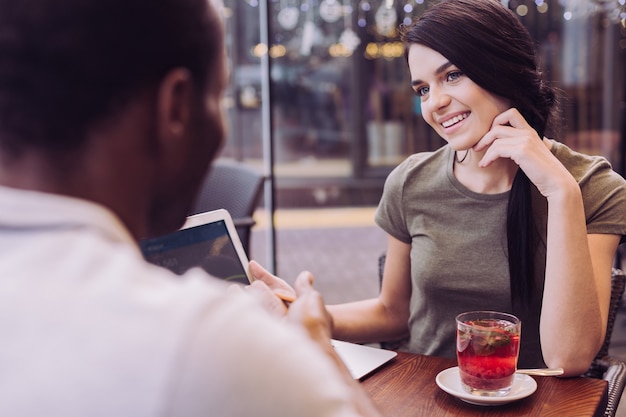 Morena atractiva mujer bonita sonriendo mientras mira al hombre y toca su rostro