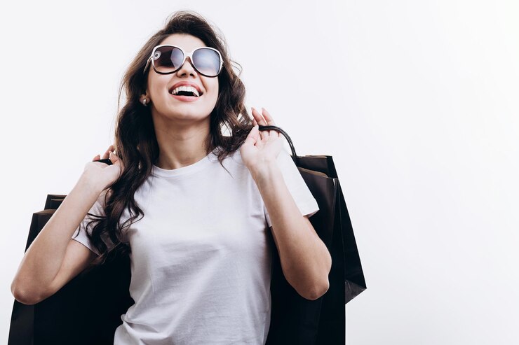 Morena atractiva sonriente llevando compras después de ir de compras