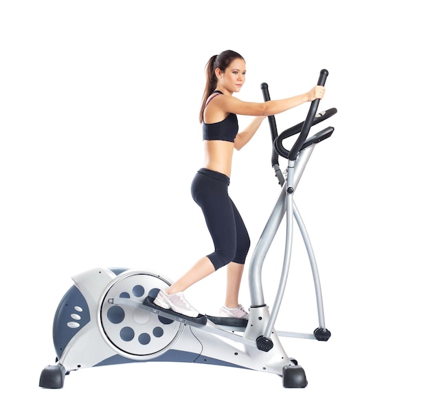 Una morena bonita haciendo ejercicios en equipos de gimnasio.