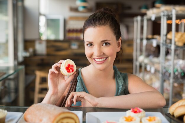 Morena bonita mostrando um cupcake