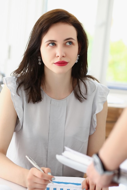 Morena bonita trabalhadora de escritório ouve as ideias de um colega de trabalho, colegas discutem o momento de trabalho