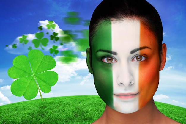 Morena com pintura facial irlandesa contra colina verde sob o céu azul