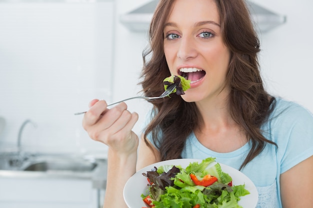 Morena comendo salada saudável