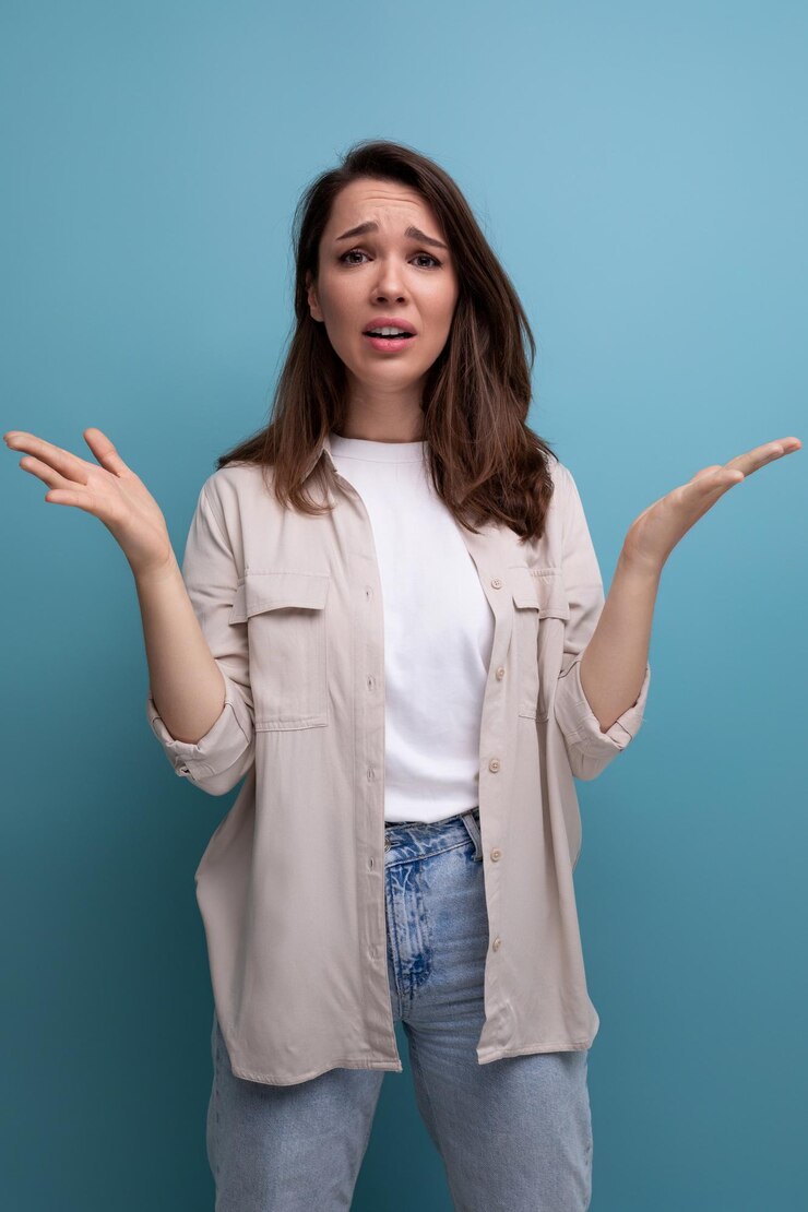 Foto morena confundida jovencita morena vestida con camisa y jeans