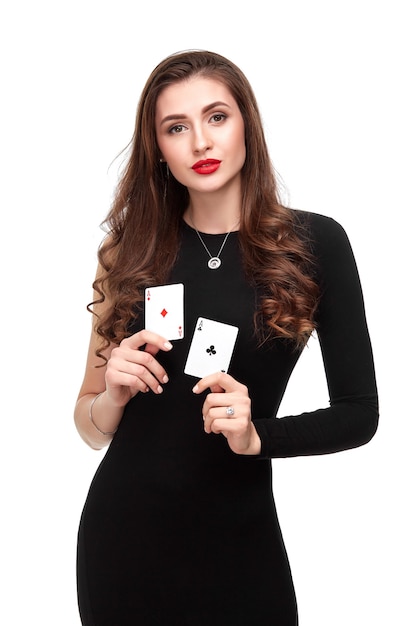 Morena de cabelo encaracolado sexy posando com duas cartas de ases em seu isolamento de conceito de pôquer de mãos em branco ba ...