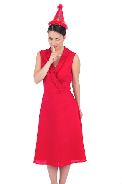 Morena elegante em vestido vermelho preparando uma festa secreta