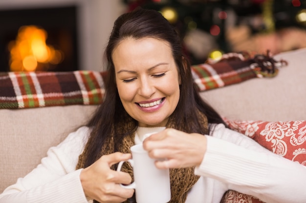 Morena feliz em roupas de inverno segurando a caneca