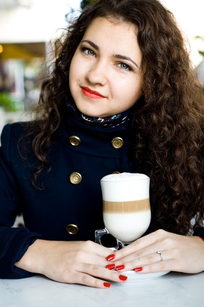 Morena hermosa joven en un café de la calle