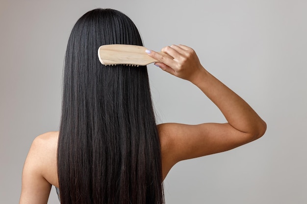 Morena jovem escovando o cabelo no estúdio