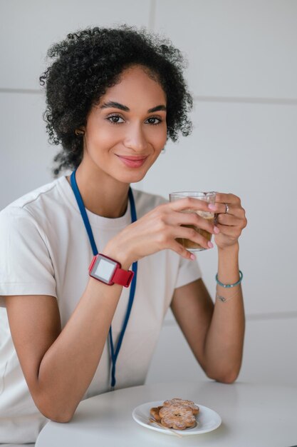 Morena jovem na cantina do escritório tendo uma pausa para o café