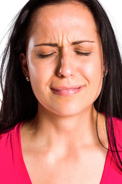 Foto morena jovem triste chorando em close-up no fundo branco