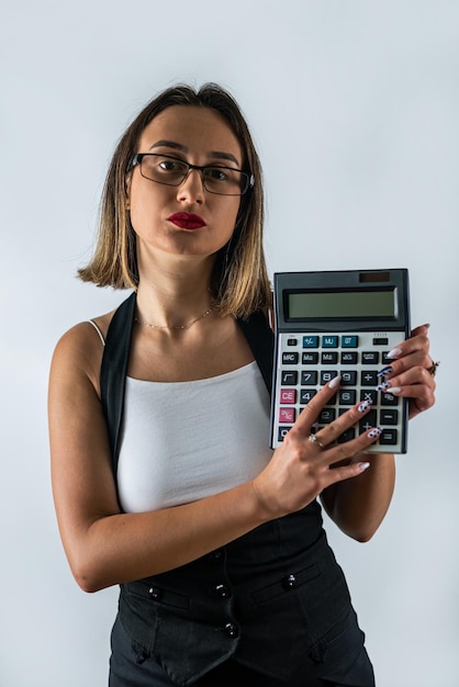 Foto morena joven dama sosteniendo una calculadora gritando con gafas aislado sobre fondo azul.