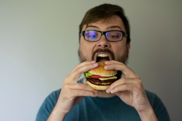 Morena joven guapo comiendo hamburguesas de comida rápida