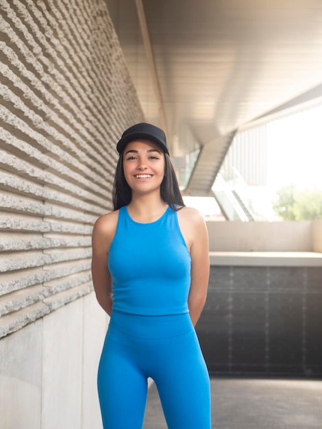 Morena joven optimista fuera del edificio iluminado por el sol