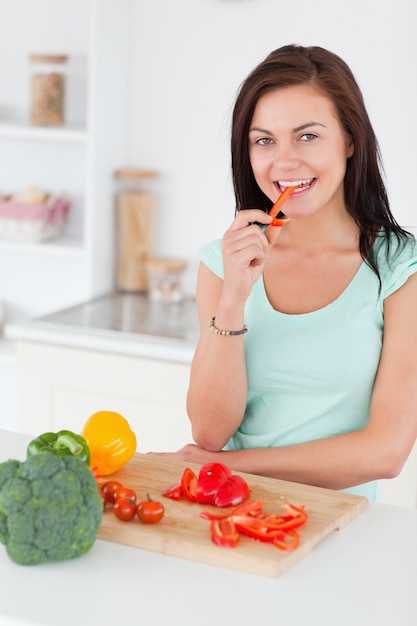 Morena linda comendo uma fatia de pimenta