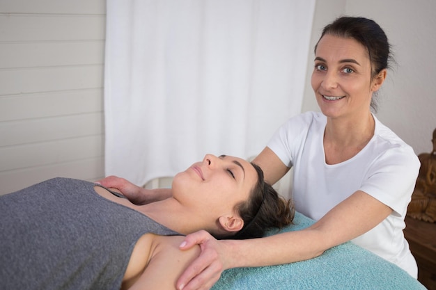 Morena pacífica recibiendo terapia de reiki en el spa de salud