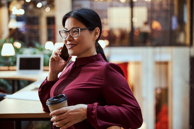 Morena positivamente encantada disfrutando de su descanso para tomar café