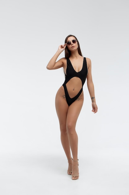 Morena sexy caliente en bikini negro y gafas de sol