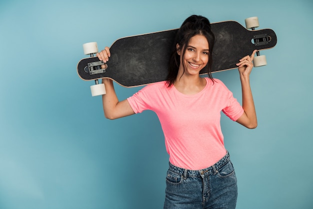 Morena sonriente, positiva sosteniendo un patín. La niña se pone de pie.