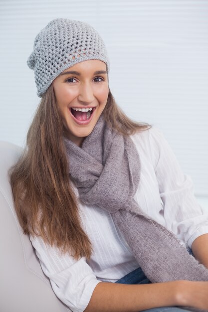 Morena sorridente atraente com chapéu de inverno em posar