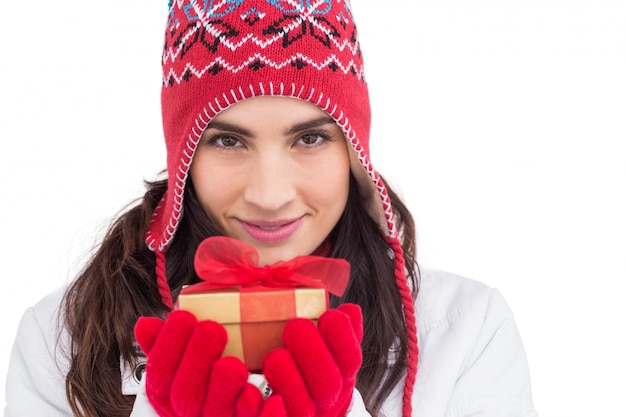 Foto morena sorridente em roupas de inverno com presente