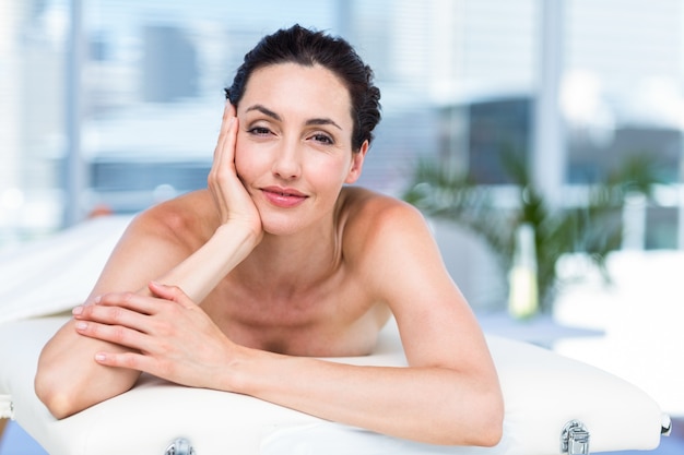 Morena sorridente relaxando na mesa de massagem