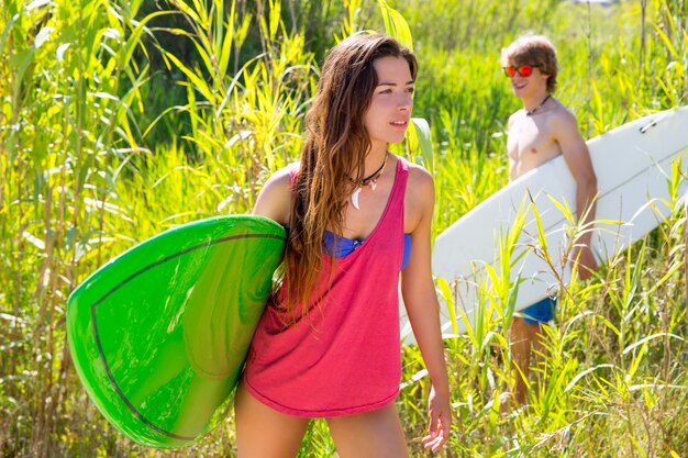 Morena surfista caminhando na selva