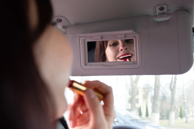 La morena se tiñe los labios en el coche