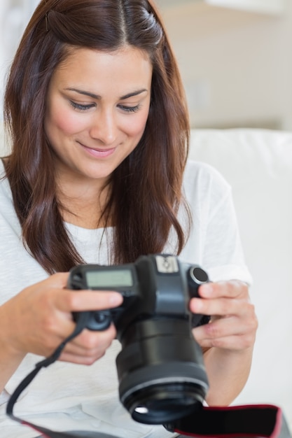 Morena viendo fotos mientras está sentado en el sofá