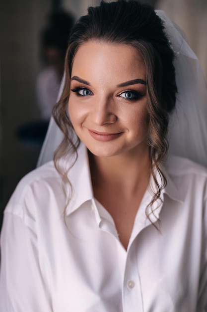 Morgen der Braut in einem weißen Gewand und einem Schleier im Raum Hochzeitsvorbereitungen